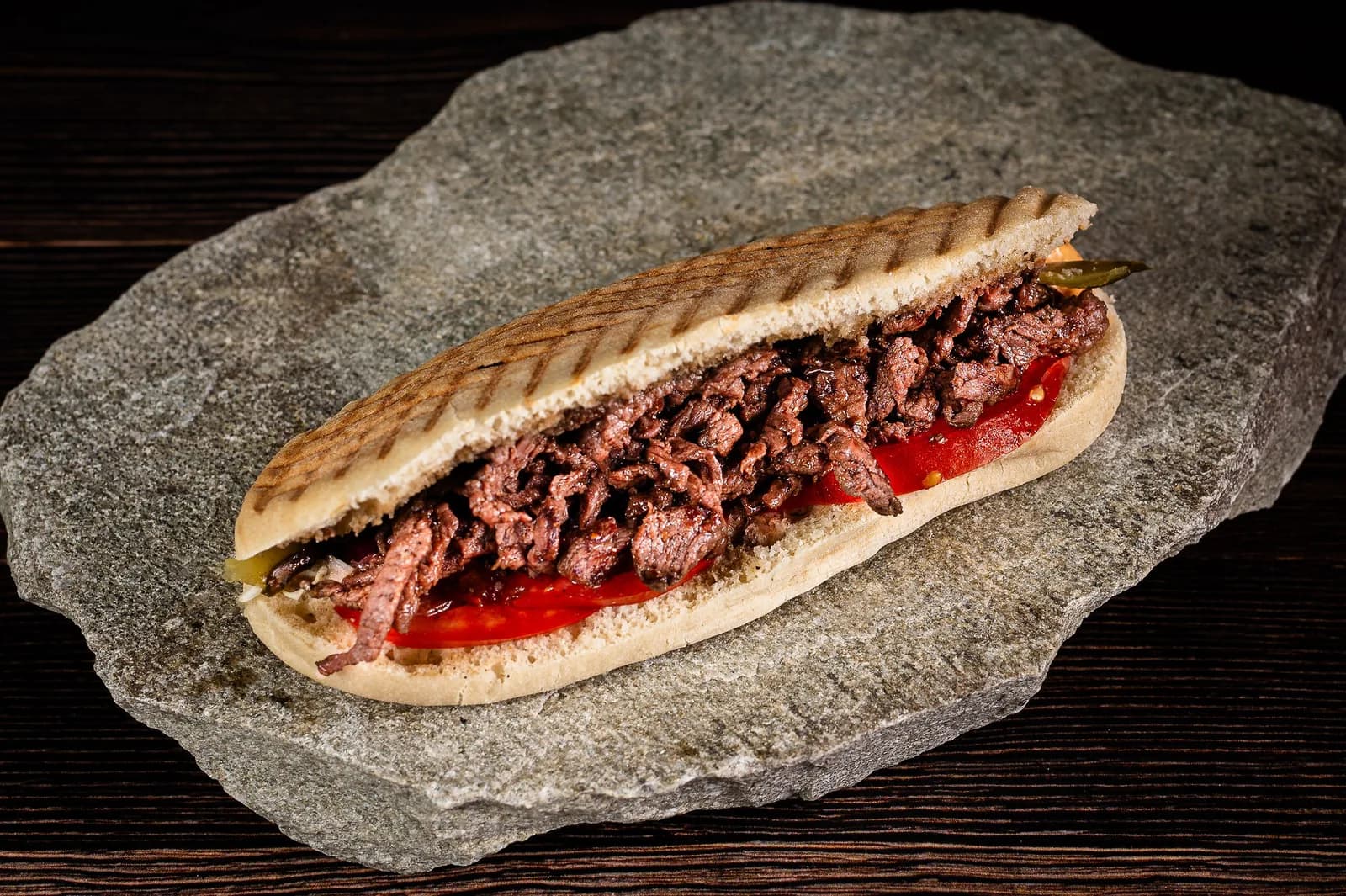 Baghetă Rosto văzută din lateral, cu carne de vită și felii de roșie